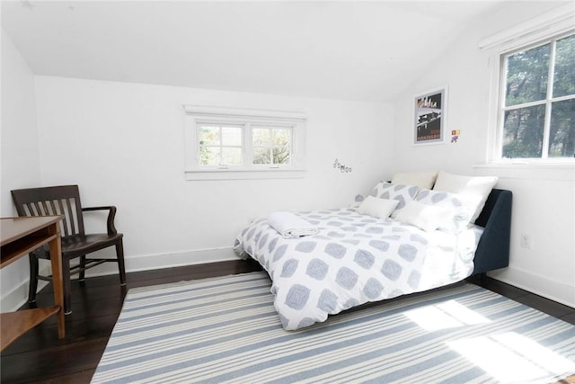 bedroom featuring dark hardwood / wood-style floors, multiple windows, and lofted ceiling