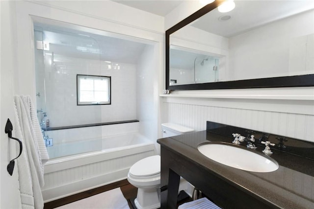 full bathroom with hardwood / wood-style floors, vanity, toilet, and tiled shower / bath