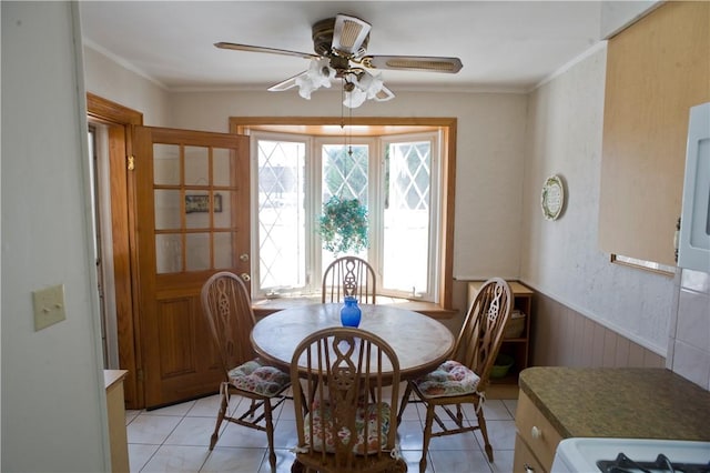 dining area with light tile patterned floors, ceiling fan, and ornamental molding