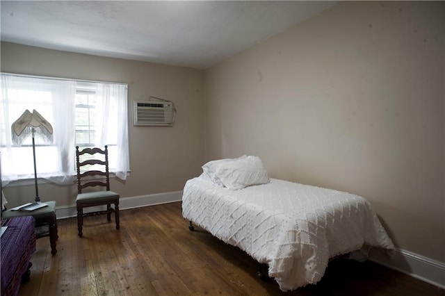 bedroom with dark hardwood / wood-style floors and a wall mounted AC