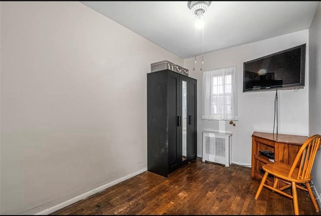 sitting room with dark hardwood / wood-style floors and radiator heating unit