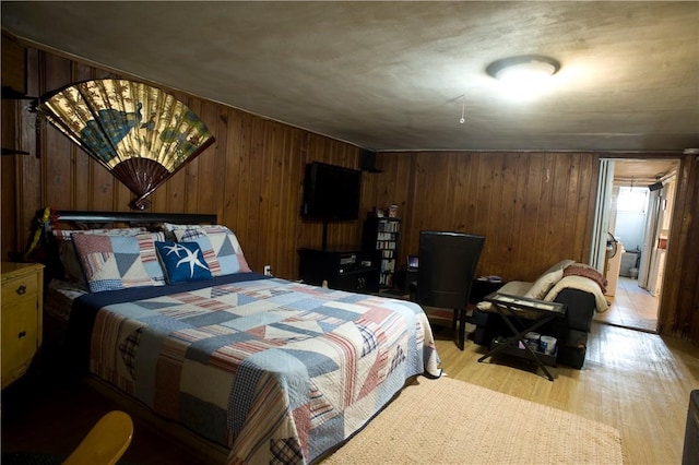 bedroom featuring light hardwood / wood-style floors and wooden walls