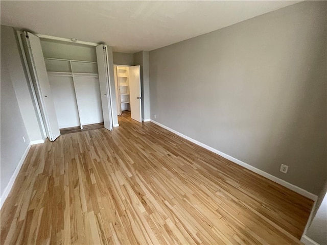 unfurnished bedroom with light hardwood / wood-style floors and a closet