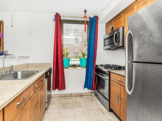 kitchen with stainless steel appliances, light stone counters, and sink