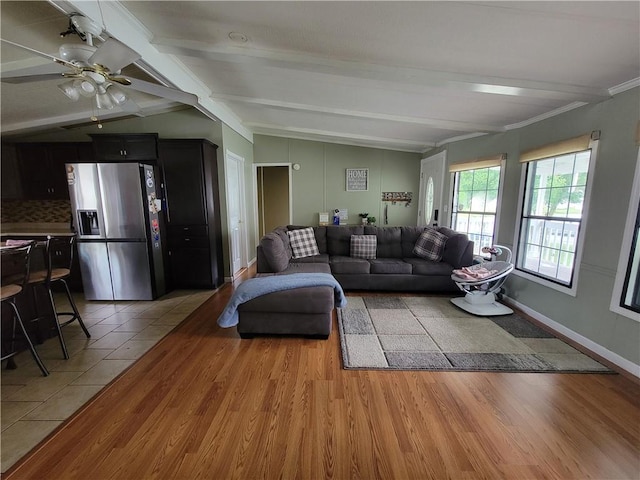 living room featuring lofted ceiling with beams, ceiling fan, and light hardwood / wood-style flooring