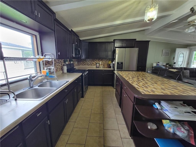 kitchen with ceiling fan, sink, stainless steel appliances, wood counters, and lofted ceiling with beams