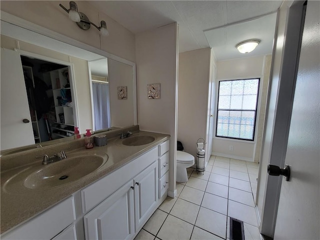 bathroom featuring tile patterned flooring, vanity, and toilet