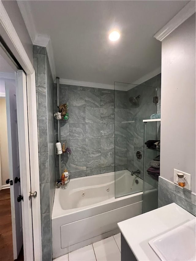 bathroom featuring tile patterned flooring, tiled shower / bath combo, crown molding, and sink