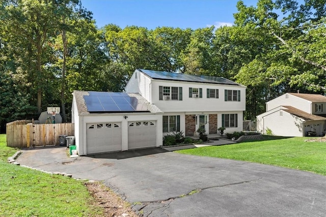 view of front of property with solar panels, a garage, and a front yard