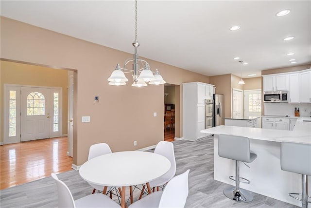 dining area featuring an inviting chandelier and light hardwood / wood-style flooring