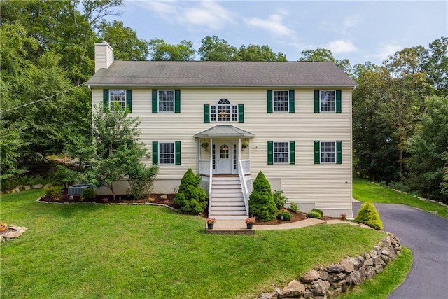 colonial home with a porch and a front yard