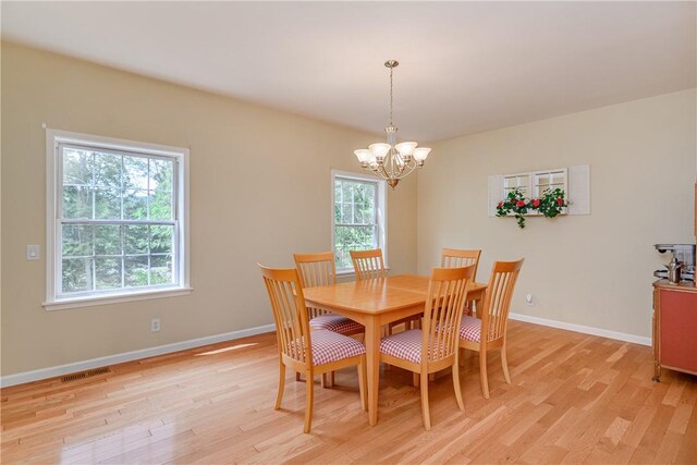 dining area featuring a notable chandelier and light wood-type flooring