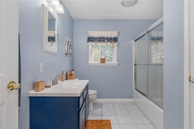 full bathroom featuring tile patterned flooring, vanity, toilet, and bath / shower combo with glass door