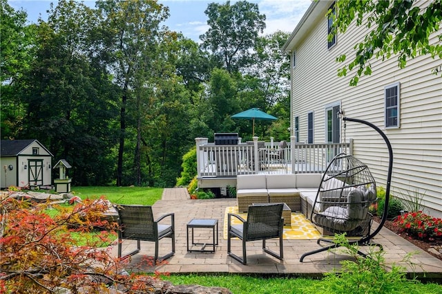 view of patio with a wooden deck, outdoor lounge area, and a storage unit