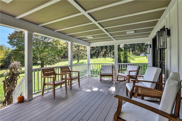 wooden deck with a lawn and covered porch