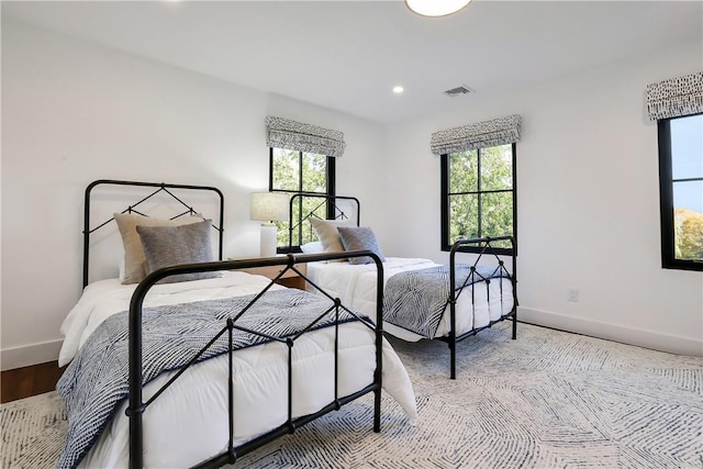 bedroom with hardwood / wood-style floors and multiple windows