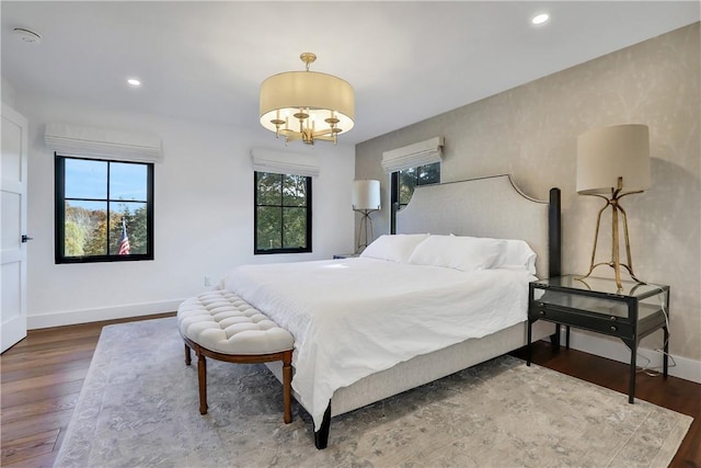 bedroom featuring a notable chandelier and dark hardwood / wood-style floors