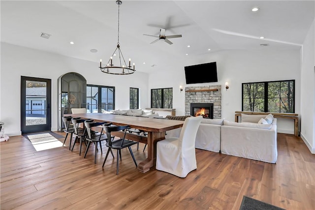 dining room with a fireplace, hardwood / wood-style floors, high vaulted ceiling, and french doors