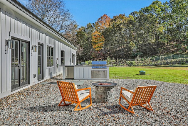 view of patio featuring a fire pit, area for grilling, and an outdoor kitchen