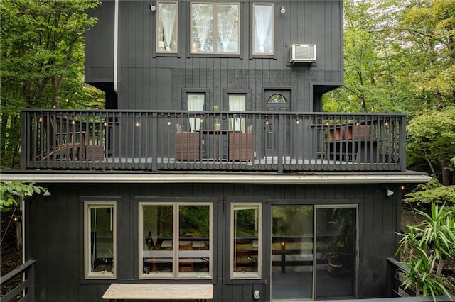 rear view of house with a balcony and a wall unit AC