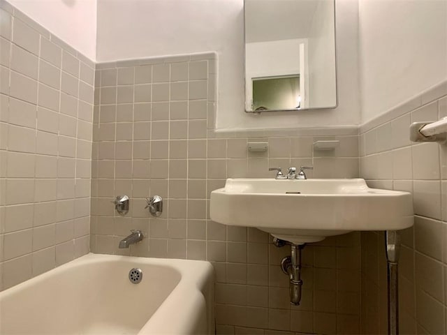 bathroom with a bathtub and tile walls