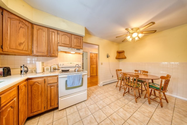 kitchen featuring white electric stove, light tile patterned floors, a baseboard radiator, light countertops, and under cabinet range hood