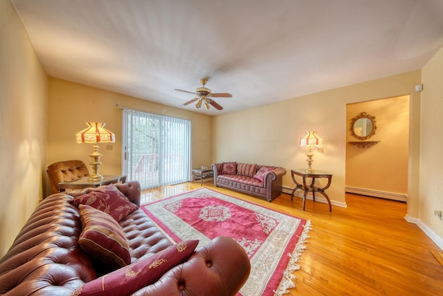 living area featuring a baseboard radiator, ceiling fan, baseboards, and wood finished floors