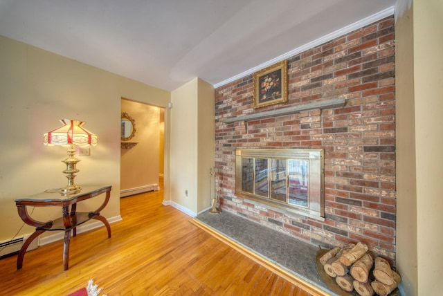 living area with a brick fireplace, light wood-style flooring, a baseboard heating unit, and baseboards