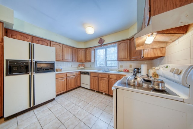 kitchen with tasteful backsplash, white appliances, light countertops, and under cabinet range hood