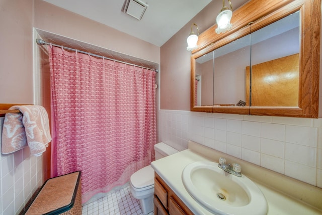 full bath featuring tile walls, visible vents, toilet, vanity, and tile patterned floors