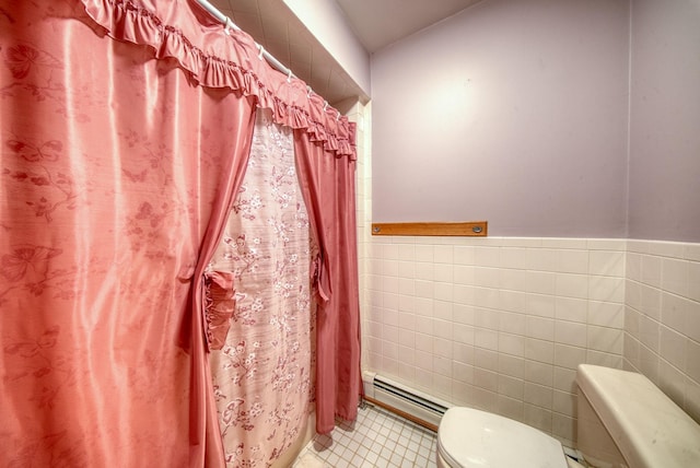 full bath featuring wainscoting, toilet, a baseboard radiator, tile patterned flooring, and tile walls