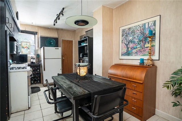 kitchen featuring light tile patterned floors, white appliances, and track lighting