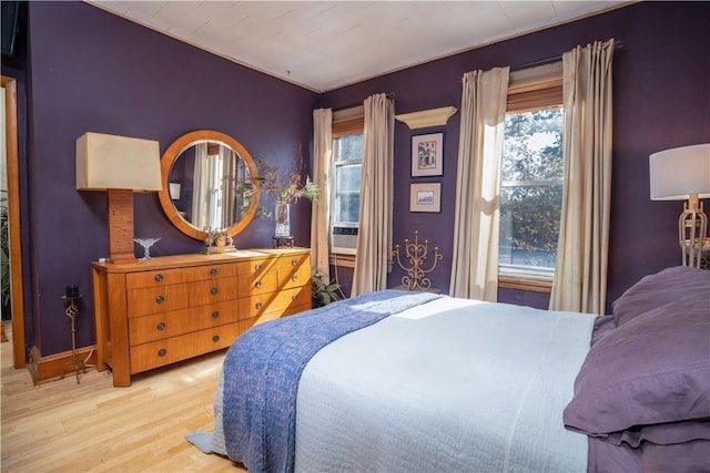 bedroom with light hardwood / wood-style flooring and crown molding