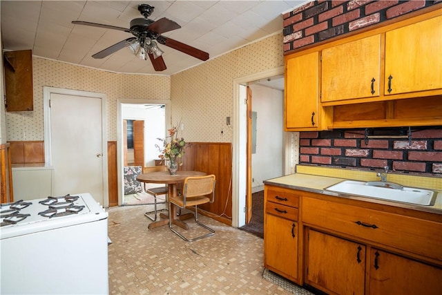 kitchen with ceiling fan, white gas range, and sink