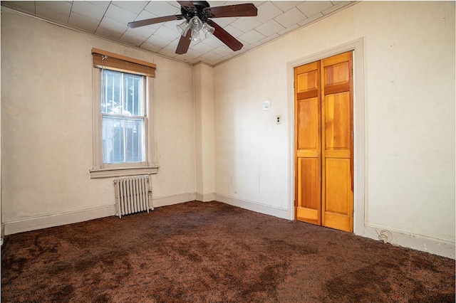 unfurnished room featuring radiator heating unit, carpet floors, and ceiling fan