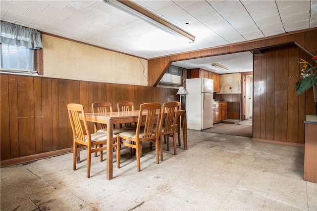 unfurnished dining area featuring wooden walls