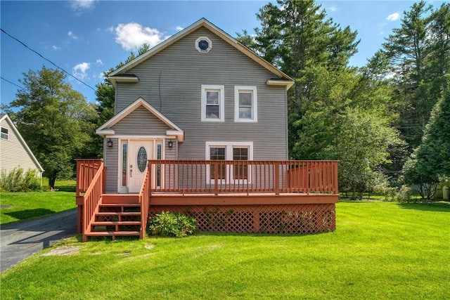 rear view of house with a deck and a lawn