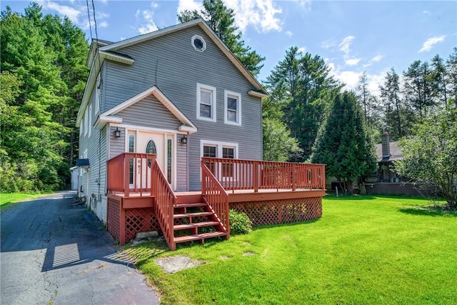 rear view of property with a deck and a yard