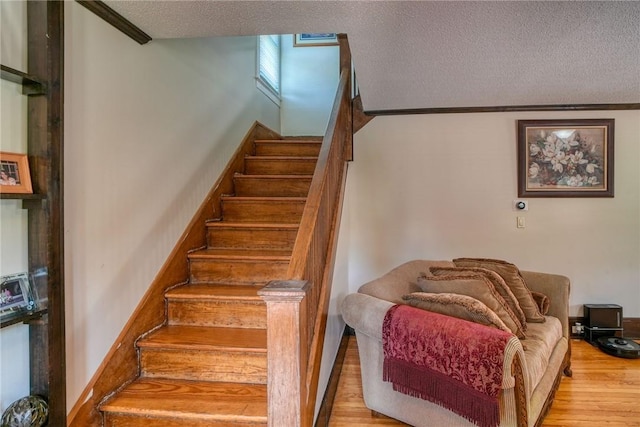 stairway featuring hardwood / wood-style floors and a textured ceiling