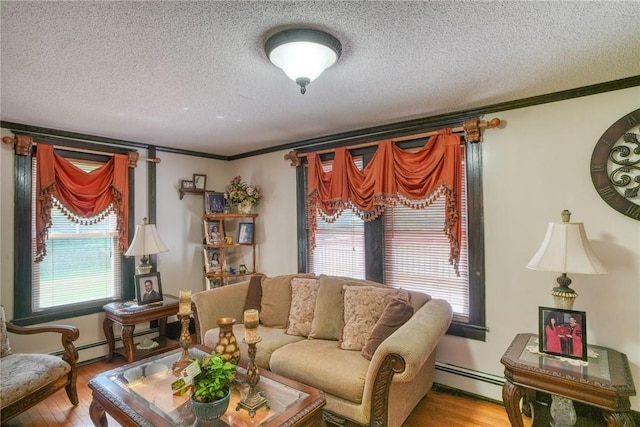 living room with hardwood / wood-style floors, a textured ceiling, a baseboard radiator, and ornamental molding