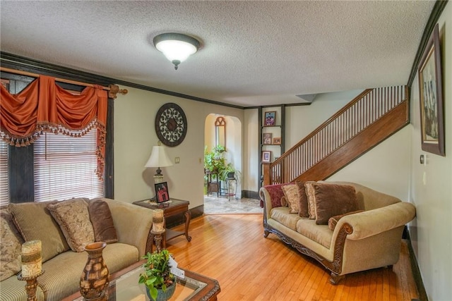 living room featuring crown molding, a textured ceiling, and hardwood / wood-style flooring