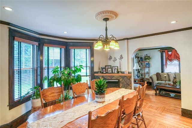 dining area with plenty of natural light, crown molding, and a chandelier