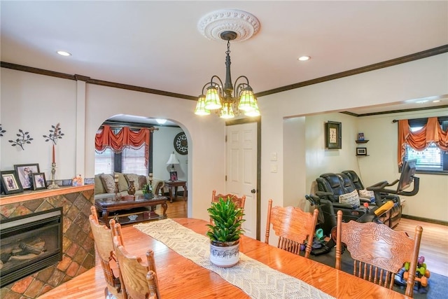 dining space featuring a chandelier, a wealth of natural light, wood-type flooring, and ornamental molding