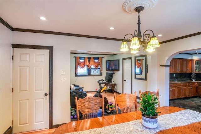 dining space with a chandelier, dark hardwood / wood-style floors, and crown molding