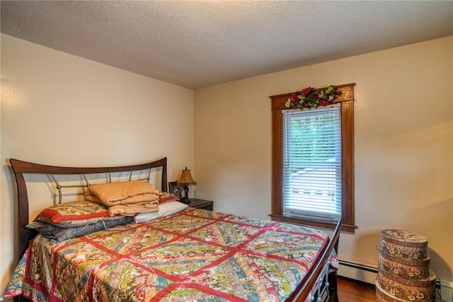 bedroom with wood-type flooring, a textured ceiling, and a baseboard heating unit