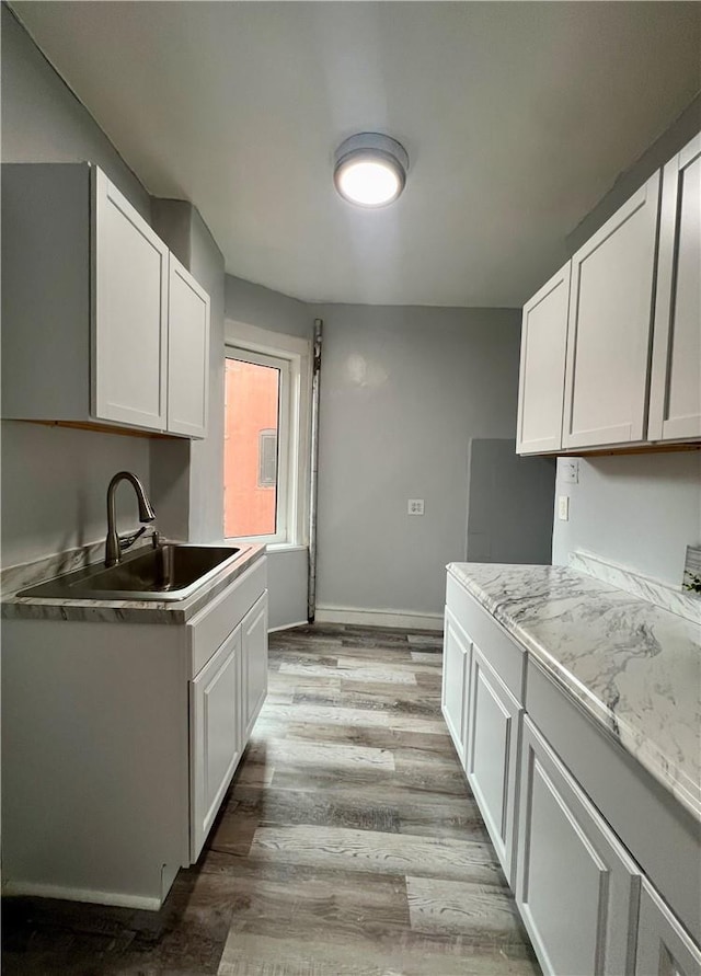 kitchen featuring light hardwood / wood-style flooring, white cabinetry, and sink