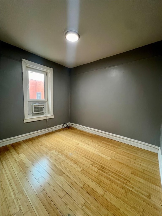 unfurnished room with light hardwood / wood-style floors and cooling unit