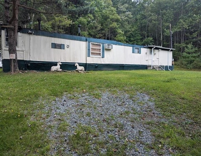 exterior space with entry steps, an AC wall unit, and a front yard