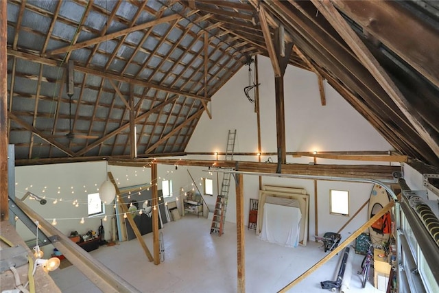 misc room with a healthy amount of sunlight, lofted ceiling, and concrete flooring