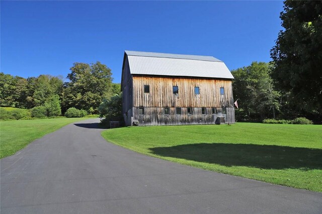 view of home's exterior featuring a yard and an outdoor structure